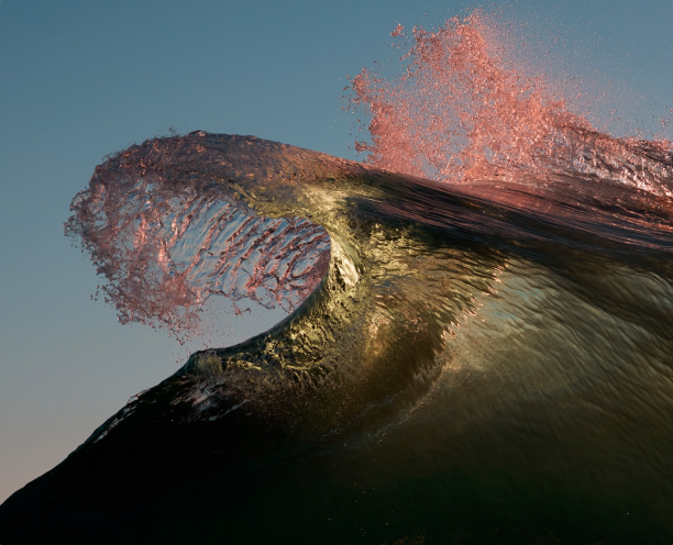 Image of a yellowish-grey wave with pink ocean spray